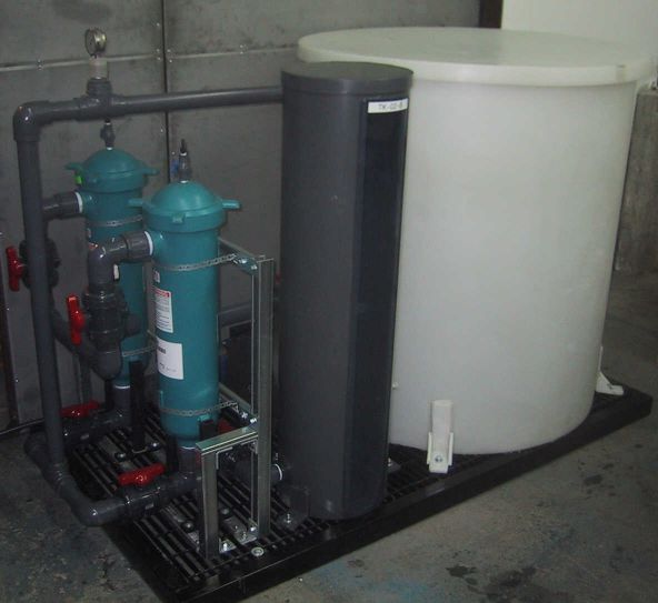 Skid mounted SX pilot plant feed delivery system with an SX feed tank, immersion heater, SX feed pump, filtration unit, and a calibration tube.