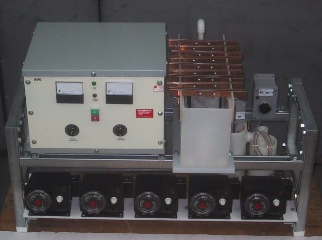 Laboratory (bench) scale electrowinning pilot plant with an electrowinning cell, anodes. cathodes, electrolyte vessels, immersion heater, circulation pump, and a rectifier.